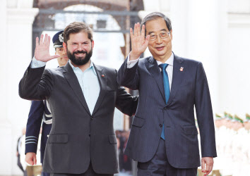 한덕수(오른쪽) 국무총리가 11일(현지시간) 칠레 산티아고 대통령궁에서 열린 공식환영식에 참석해 가브리엘 보리치 대통령과 손을 들어 인사하고 있다. [연합]