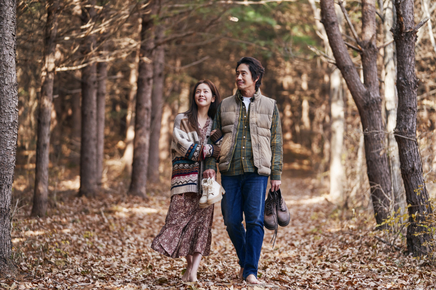 Han Ji-min (left) plays Yi-hu, a deceased wife who meets her husband, played by Shin Ha-kyun, in the imaginary world Yonder in "Beyond the Memory." (Tving)