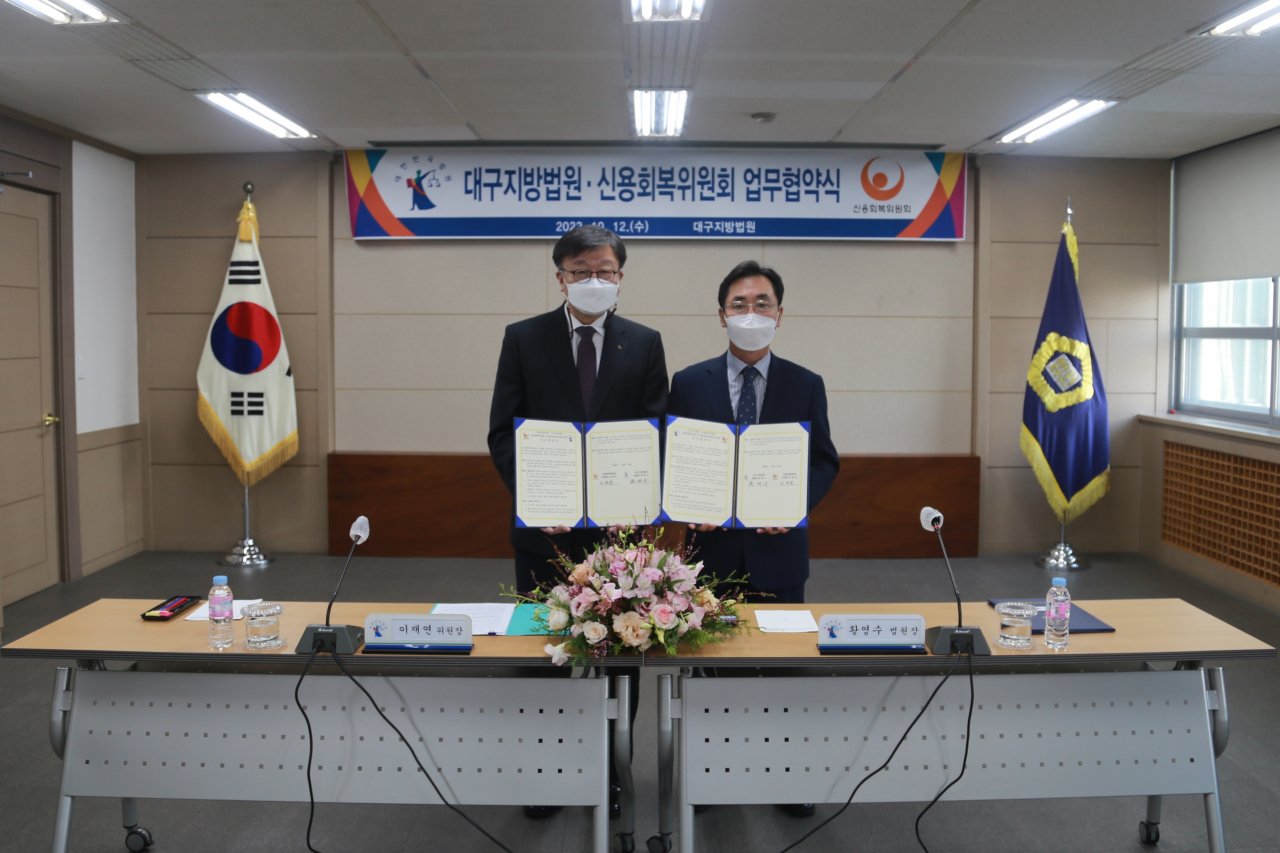 이재연(왼쪽) 신용회복위원회 위원장과 황영수 대구지방법원 법원장이 12일 대구지방법원에서 개인회생‧파산 이용자를 대상으로 신용·금융교육 지원을 위한 업무협약을 체결하고 기념촬영을 하고 있다.[신용회복위원회 제공]