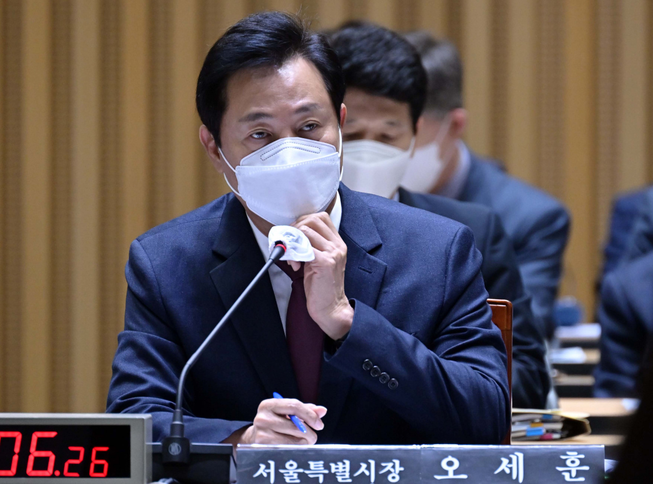 오세훈 서울시장이 12일 서울 중구 서울시청 대회의실에서 열린 국회 행정안전위원회의 서울시에 대한 국정감사에서 마스크를 고쳐쓰고 있다. [연합]