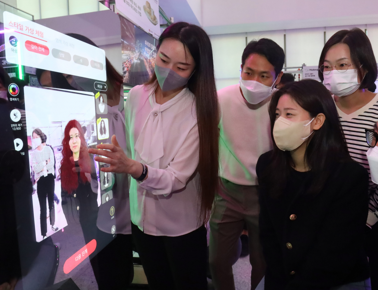 한 관람객이 지난 12~13일 서울 마곡 LG사이언스파크에서 열린 ‘슈퍼스타트 데이 2022’에서 스타트업인 ‘미러로이드’의 헤어 스타일링 가상체험 기기인 ‘스마트 미러’를 체험하고 있다. [㈜LG 제공]