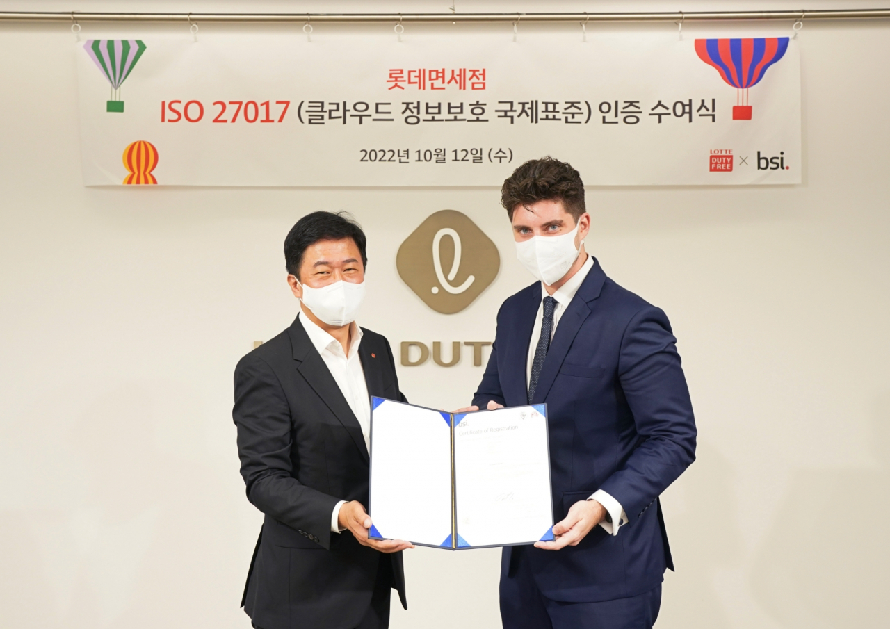 12일 서울 중구 롯데면세점 본사에서 열린 ISO 27017 인증 수여식에서 이갑 롯데면세점 대표이사(왼쪽)와 톰 헬름 주한 영국대사관 서기관이 기념촬영을 하고 있다.[롯데면세점 제공]