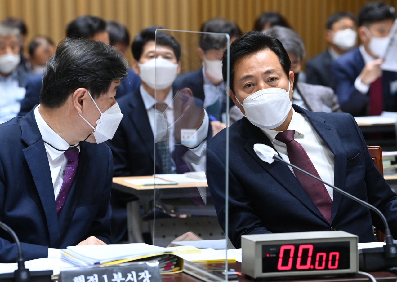오세훈 서울시장이 14일 오전 서울시청 대회의실에서 열린 국회 국토교통위원회의 서울시에 대한 국정감사에서 김의승 서울시 행정1부시장과 대화하고 있다. [연합]