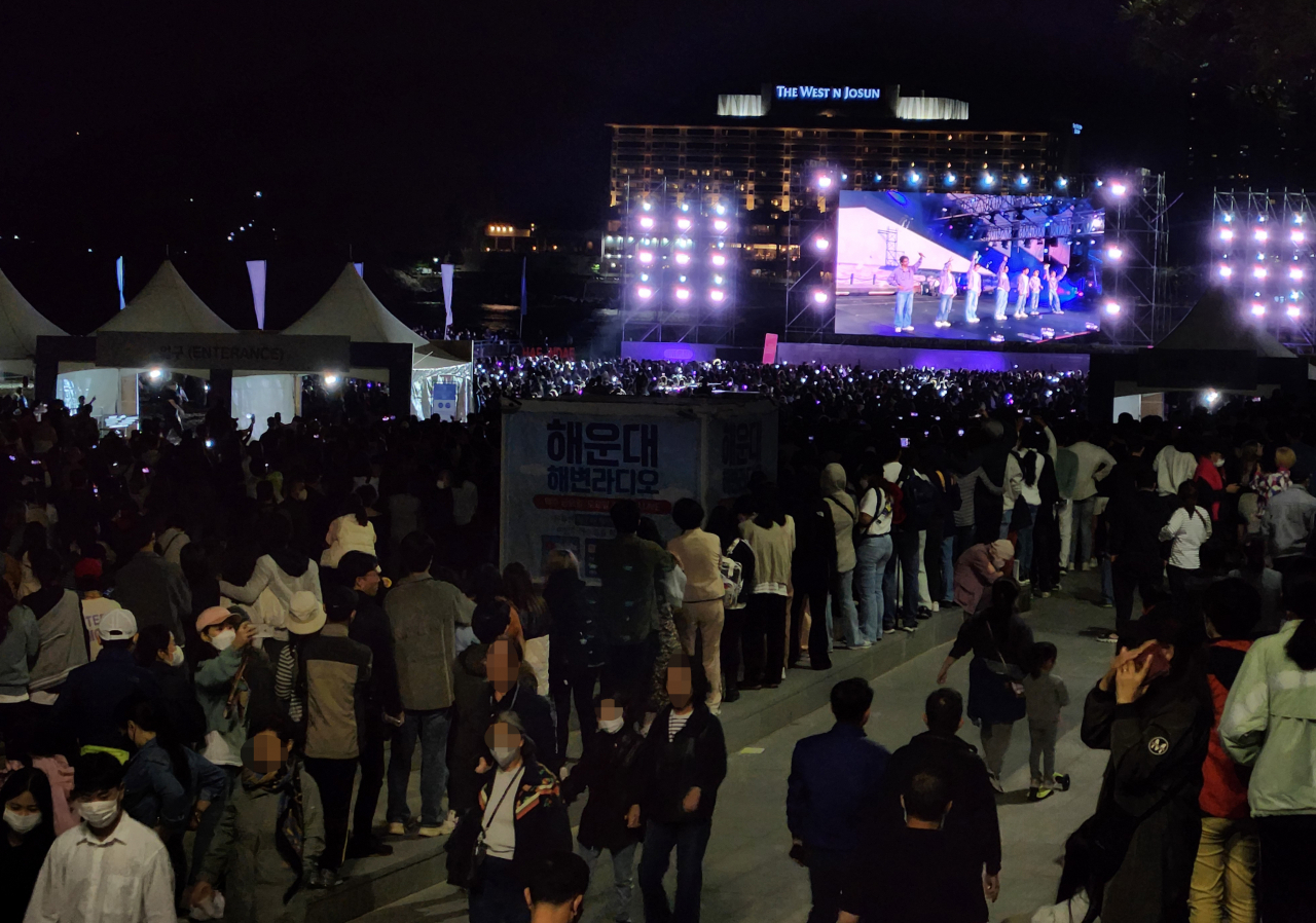 People watch BTS‘ “BTS ’Yet to Come‘ in Busan” concert in support of Busan’s bid to host the 2030 World Expo, in Haeundae Beach, Busan, Saturday. (Yonhap)