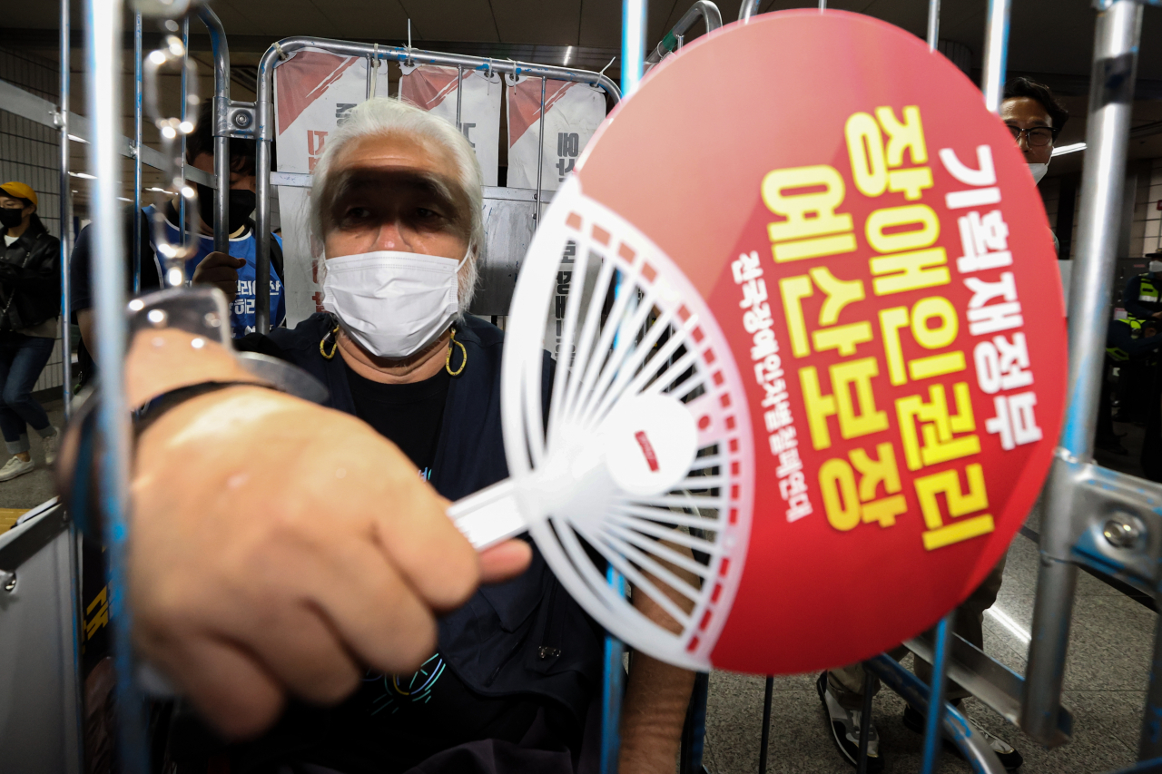 박경석 전국장애인차별철폐연대(전장연) 상임공동대표가 지난달 28일 서울 9호선 여의도역에서 철창에 들어가 수갑을 찬 채로 출근길 지하철 탑승 시위를 벌이고 있다. [연합]