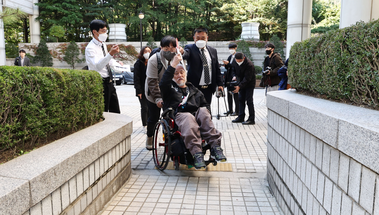 Park Kyoung-seok, head of Solidarity Against Disability Discrimination (SADD), enters the Seoul Central District Court on Tuesday. (Yonhap)