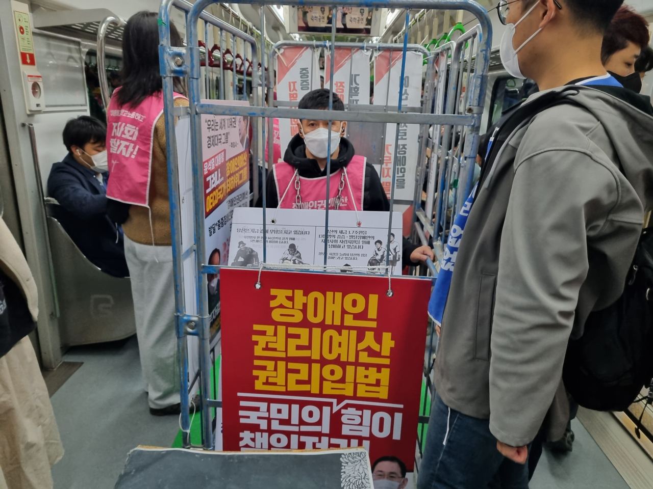 19일 오전 8시께 전국장애인차별철폐연대(전장연)이 서울 지하철 2호선 교대역 당산역 방향 1-1 승강장에서 ‘제40차 출근길 지하철 탑니다’ 시위를 하고 있다. 한 전장연 관계자가 카트 속에 몸을 실은 채 열차에 탑승히고 있다. 김영철 기자