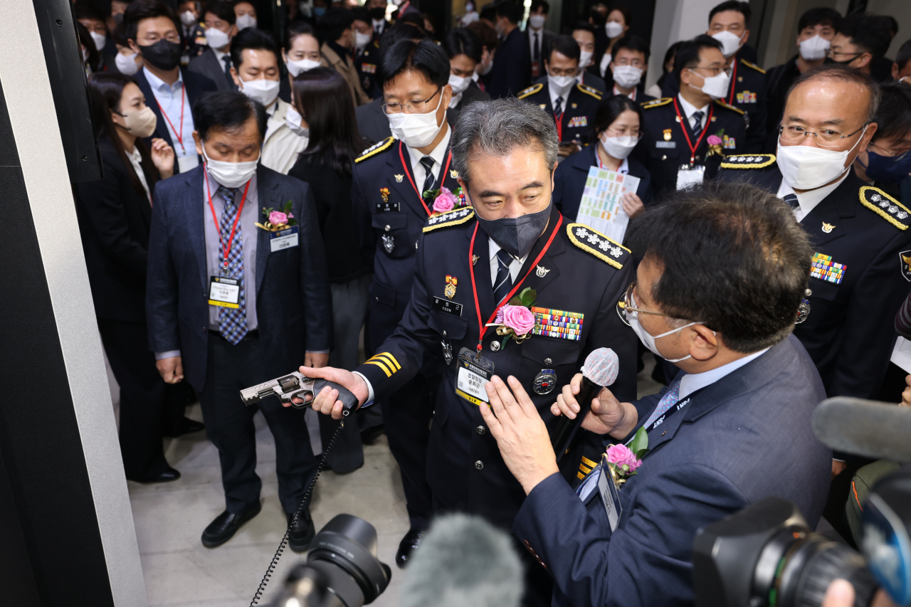 SNT모티브 특수사업본부 박문선 전무(오른쪽)가 윤희근 경찰청장에게 STRV9 9mm 저위험 권총에 대해 설명하고 있는 모습. [SNT모티브 제공]