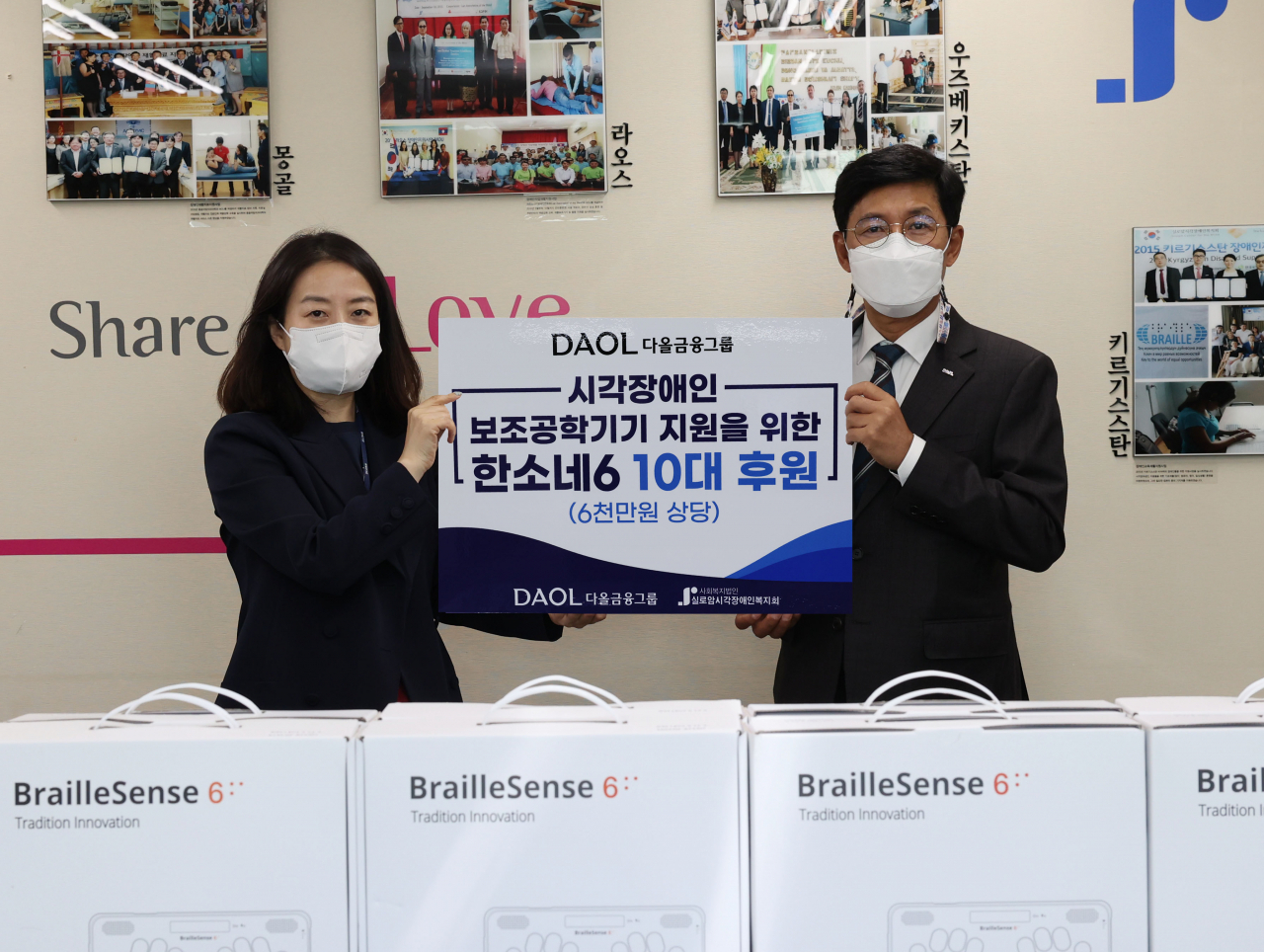 최석종 다올금융그룹 부회장(오른쪽)이 19일 시각장애인을 위한 점자정보단말기를 전달하고 김미경 실로암시각장애인복지관 관장(왼쪽)과 기념촬영을 하고 있다. [사진=다올금융그룹]