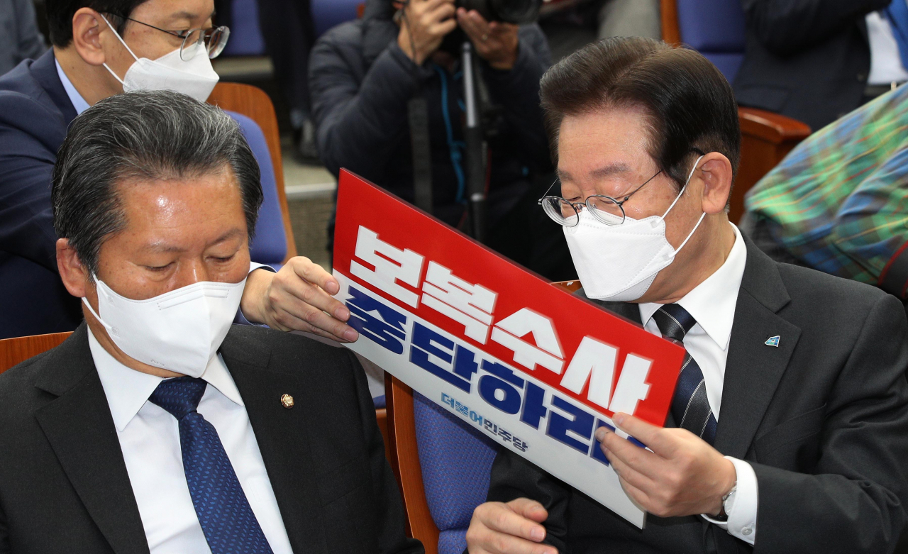 더불어민주당 이재명 대표가 20일 오전 국회에서 열린 긴급 의원총회에서 '보복수사 중단하라' 손팻말을 건네받고 있다. [사진=이상섭 기자]