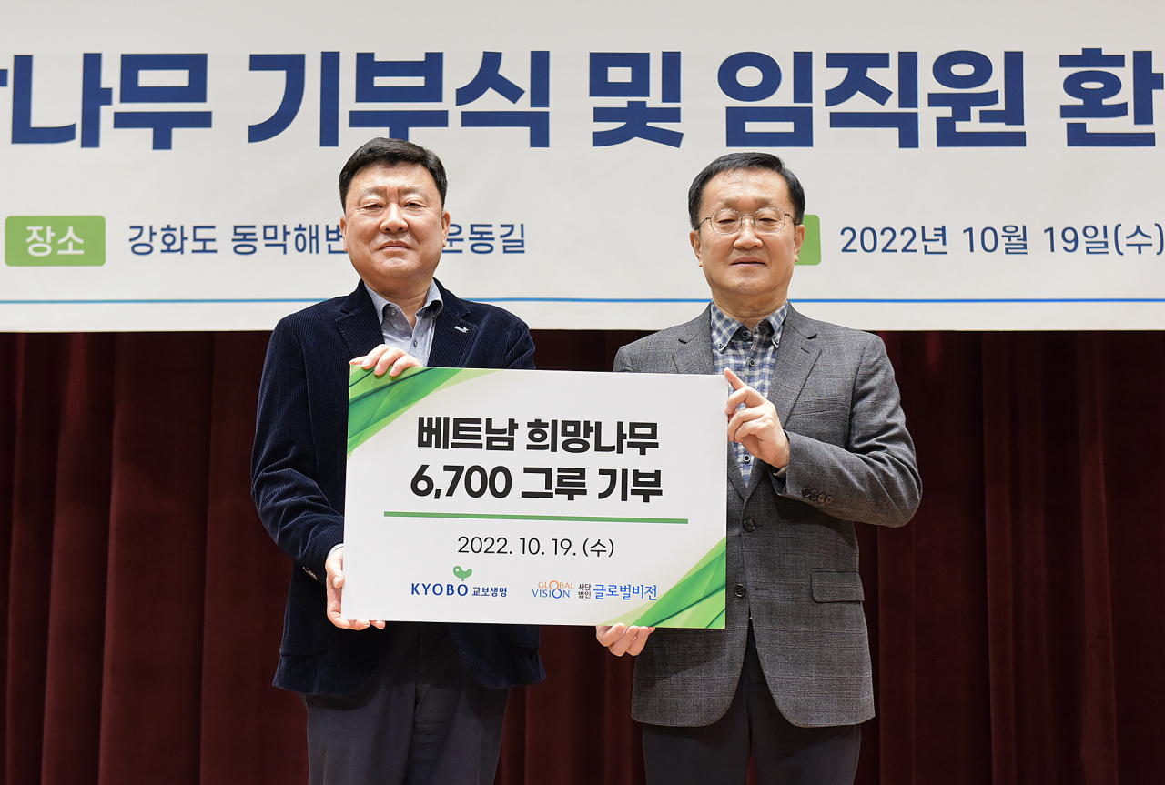 19일 서울 광화문 교보생명 본사에서 열린 '교보생명 희망나무 기부식'에서 편정범 교보생명 대표이사 사장(왼쪽)과 이기현 글로벌비전 회장이 기념촬영을 하고 있다.
