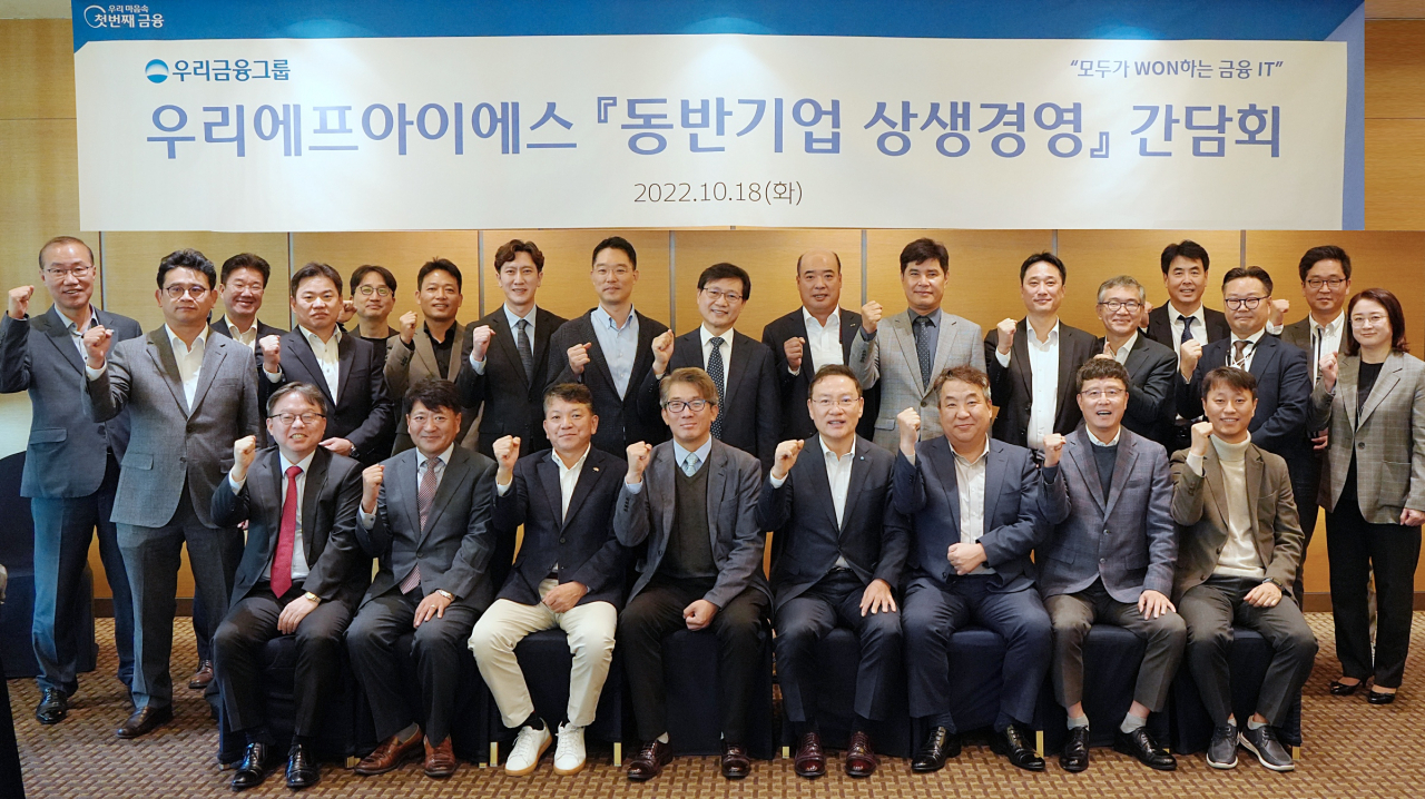 지난 18일 서울 여의도 메리어트 호텔에서 열린 ‘동반기업 상생경영 간담회’에서 우리에프아이에스 관계자들과 21개 동반기업 대표들이 기념촬영을 하고 있다.[우리에프아이에스 제공]