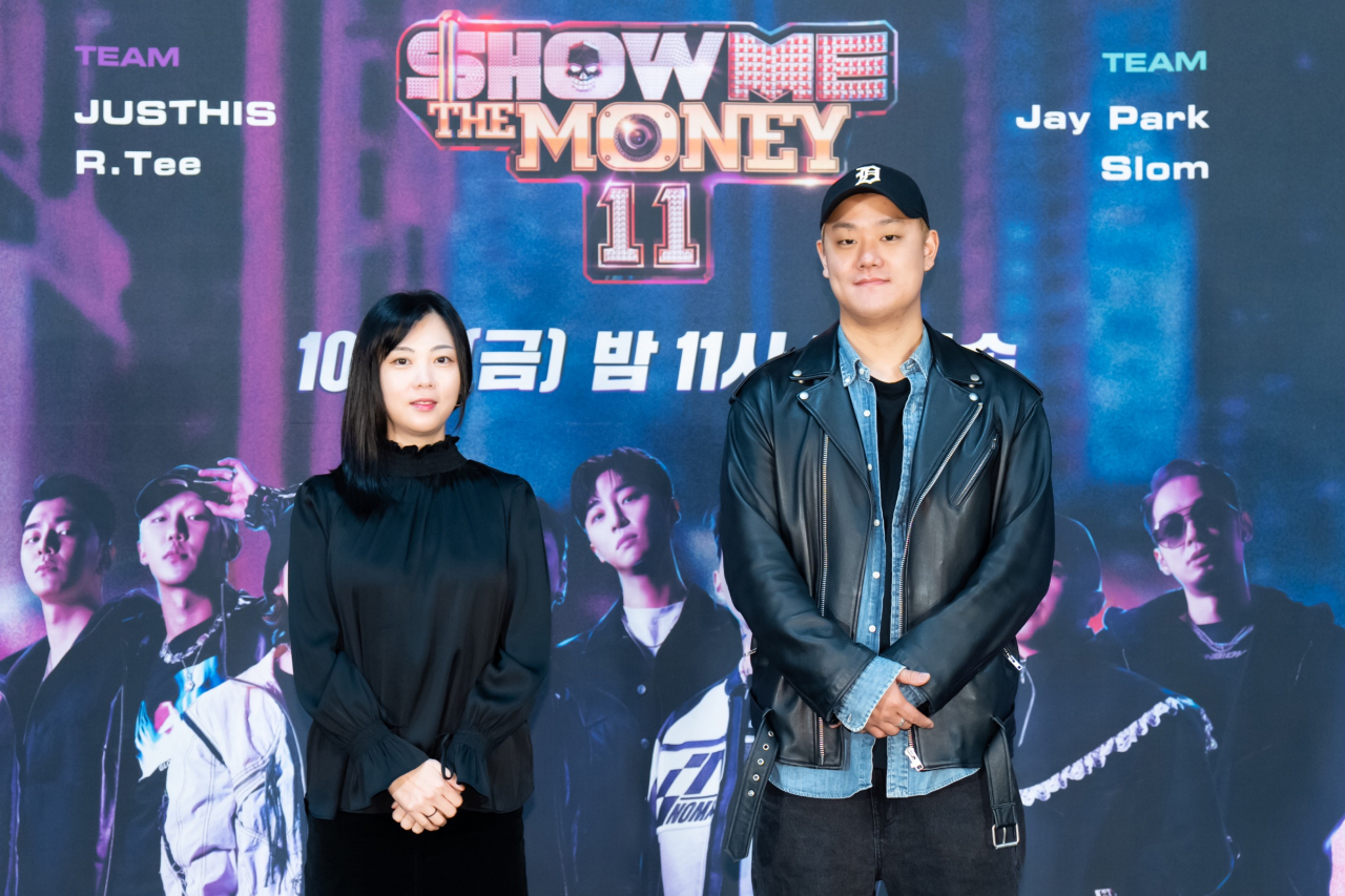 Chief producer Choi Hyo-jin (left) and producer Lee Hyung-jin of Mnet’s “Show Me the Money" pose for photos during an online press conference for the show on Friday. (Mnet)