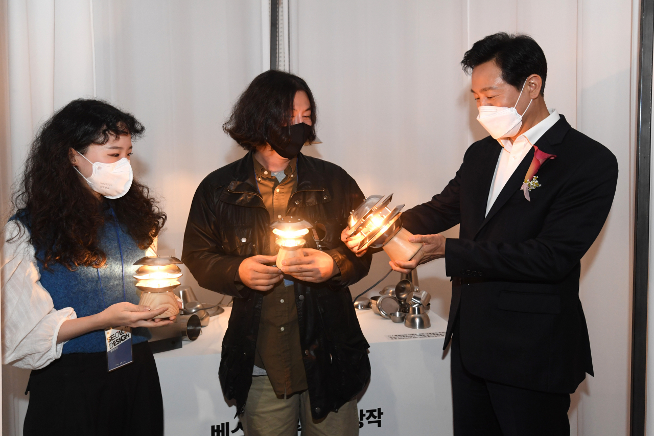 ‘2022 DDP디자인페어’ 베스트어워드 수상작인 ‘언스택 시리즈’를 제작한 박선영(왼쪽 첫번째) 대표와 조수아(왼쪽 두번째) 디자이너가 오세훈 서울시장에게 제품을 설명하고 있다. [서울시 제공]