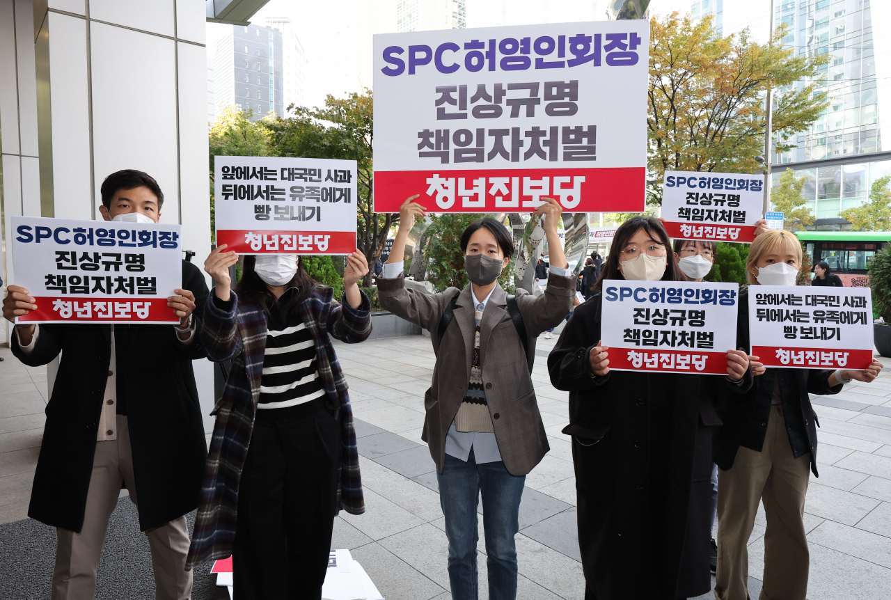 21일 오전 서울 서초구 양재동 SPC 본사 앞에서 청년진보당 관계자들이 평택 SPC 계열사 SPL의 제빵공장 사망 사고 관련 진상규명, 책임자 처벌 등을 촉구하는 팻말을 들고 있다. 연합뉴스