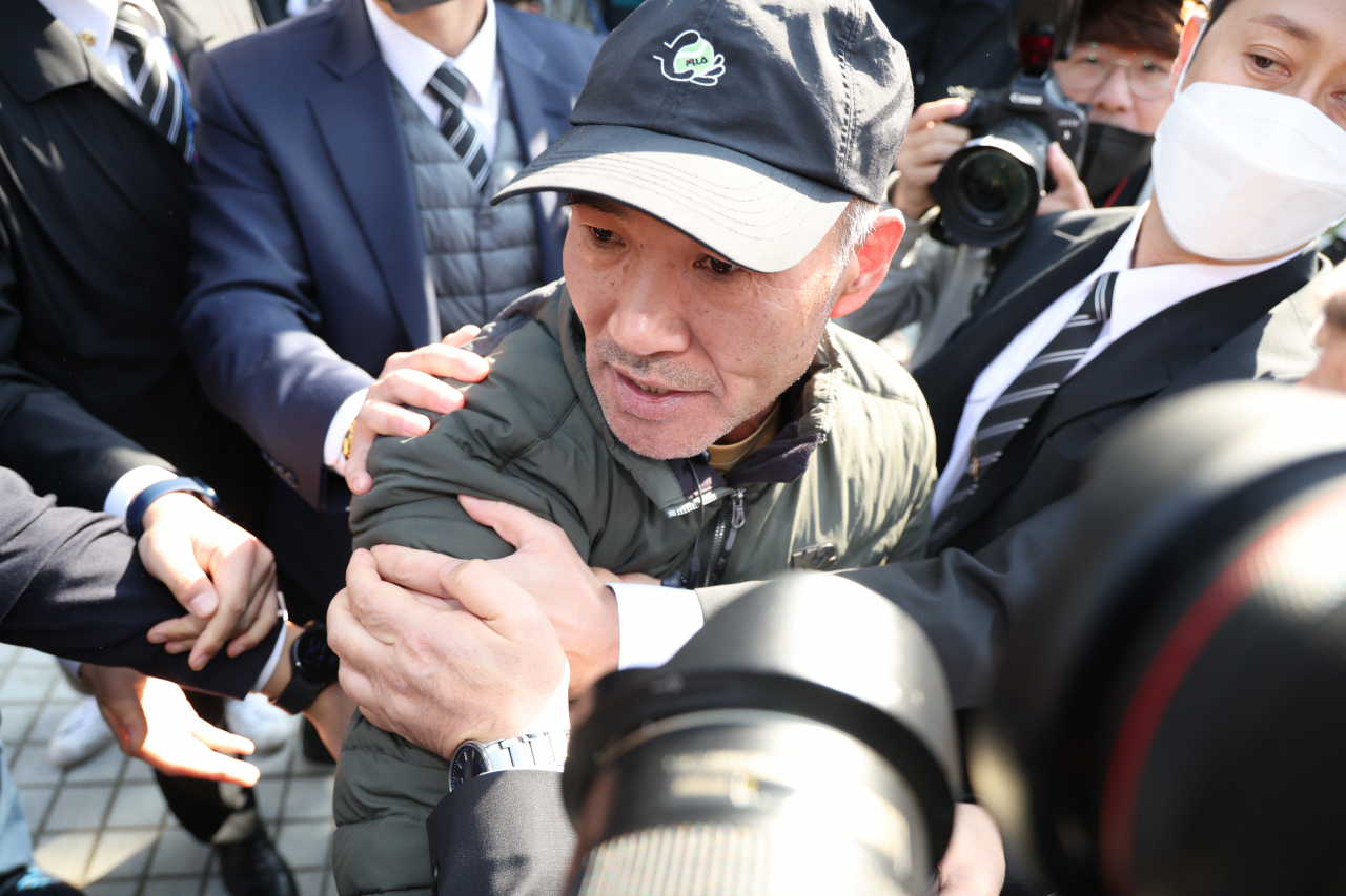 '서해 피격 공무원'의 형 이래진씨(오른쪽)가 지난 21일 서울 서초동 서울중앙지법에서 은폐 의혹과 관련해 영장실질심사를 받고 나오는 서욱 전 국방장관에게 소리치고 있다. 이씨는 서 전 장관에게 갑작스럽게 달려들었지만 방호 요원들에 의해 제지당했다. [연합]