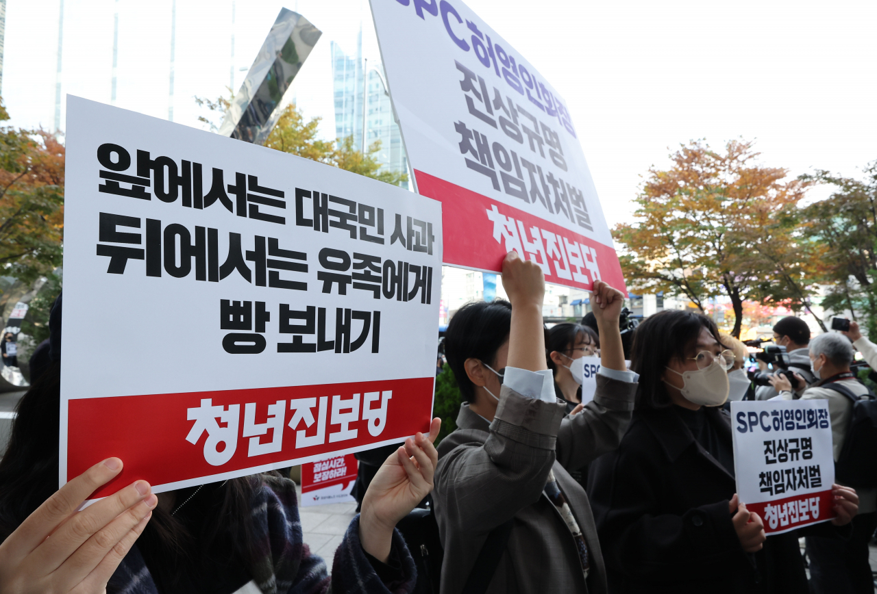 21일 오전 서울 서초구 양재동 SPC 본사 앞에서 청년진보당 관계자들이 평택 SPC 계열사 SPL의 제빵공장 사망 사고 관련 진상규명, 책임자 처벌 등을 촉구하는 팻말을 들고 있다. [연합]
