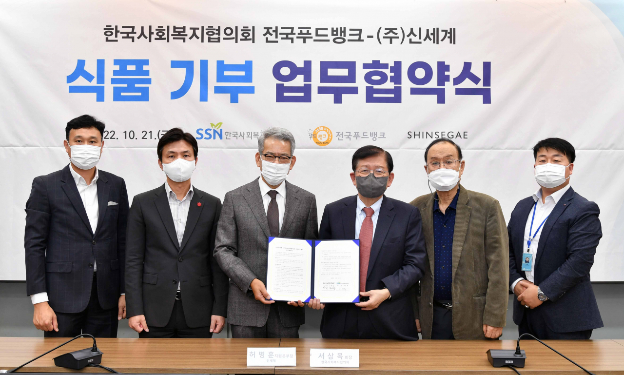 21일 서울 마포구 한국사회복지회관 6층에서 신세계백화점과 전국푸드뱅크가 업무협약 기념 촬영을 하고 있다. 좌측부터 신세계백화점 ESG추진팀 박종섭 팀장, ESG추진사무국 이원호 담당,신세계백화점 지원본부장 허병훈 부사장, 한국사회복지협의회 회장 서상목, 한국사회복지협의회 부회장 최일섭, 전국푸드뱅크 사업단장 강훈. [신세계백화점 제공]