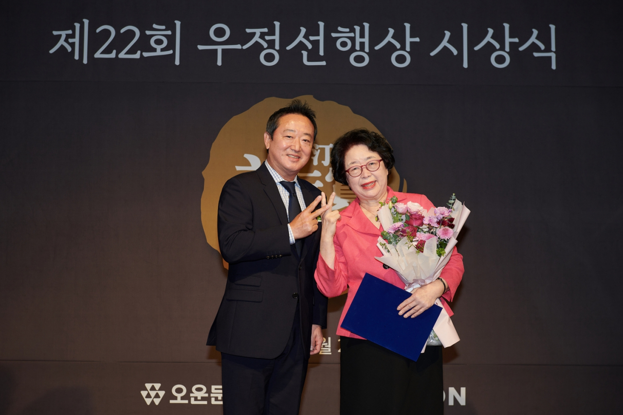 제22회 우정선행상 시상식에서 대상을 수상한 최경숙씨(오른쪽)와 이웅열 오운문화재단 이사장이 기념사진을 찍고 있다.
