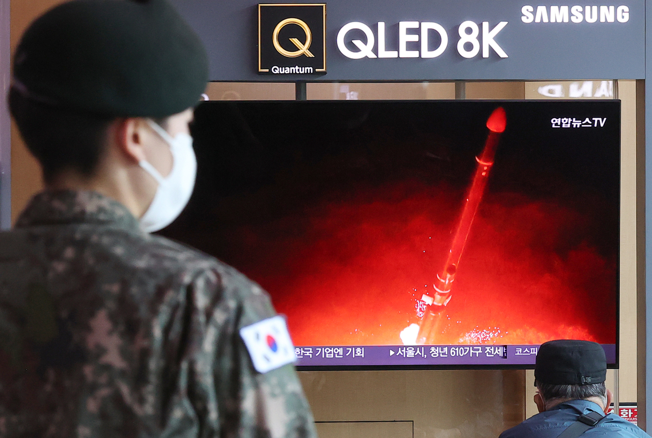 Passersby watch a TV report of North Korea's missile launch at Seoul Station. (File Photo - Yonhap)