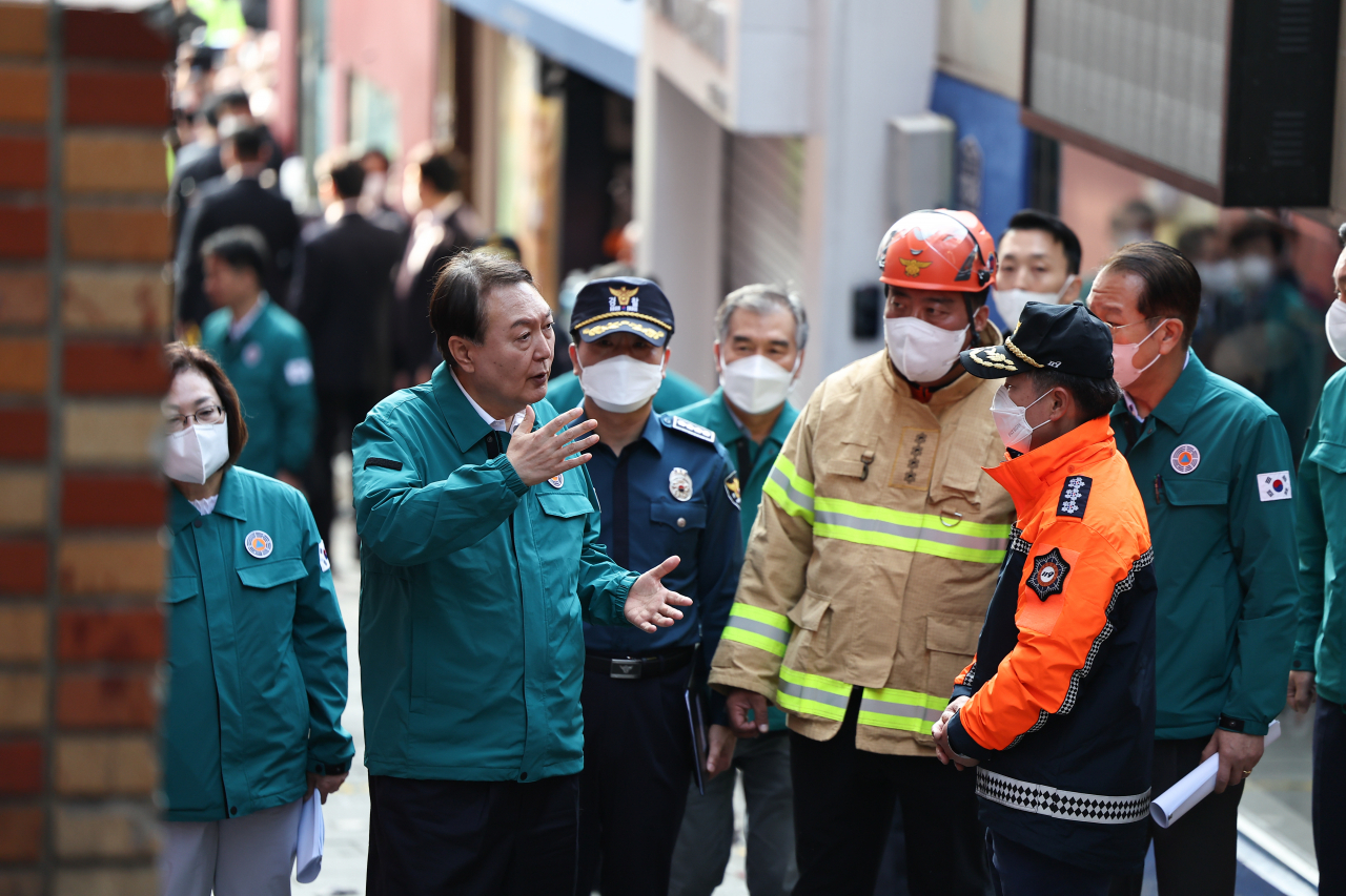 윤석열 대통령이 30일 오전 서울 용산 이태원 참사 현장을 살펴보며 관계자들과 대화하고 있다. [연합]