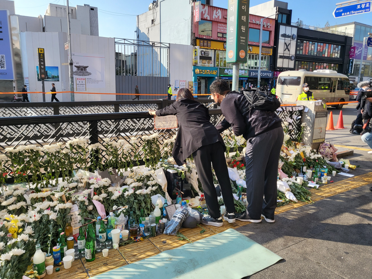 31일 오전 서울 용산구 이태원동 이태원역 1번 출구 앞. 시민들이 자신들이 써온 추모 문구를 붙이고 있다. 이들 앞으로 추모의 의미로 쌓은 국화들이 놓여 있다. 박혜원 기자