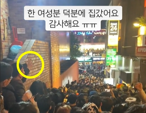 지난 29일 이태원 참사가 발생했던 골목길의 참사 발생 수시간 전 모습. 한 여성이 손을 흔들면서 인파를 정리해 질서가 유지되고 있다. [틱톡 캡처]