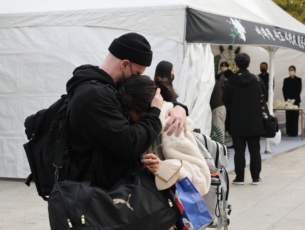 People visiting a mourning altar at Noksapyeong Station, close to where the tragedy happened, embrace each other on Tuesday. (Yonhap)