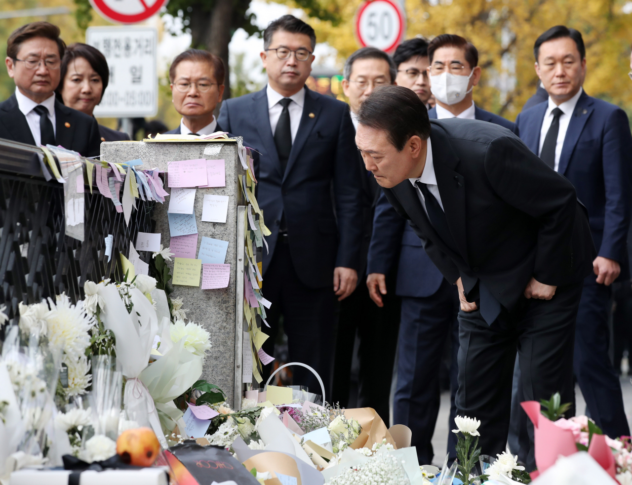윤석열 대통령이 1일 서울 용산구 이태원역 1번 출구 앞 이태원 참사 추모 공간을 방문, 헌화한 뒤 시민들의 추모 메시지를 읽고 있다. [연합]