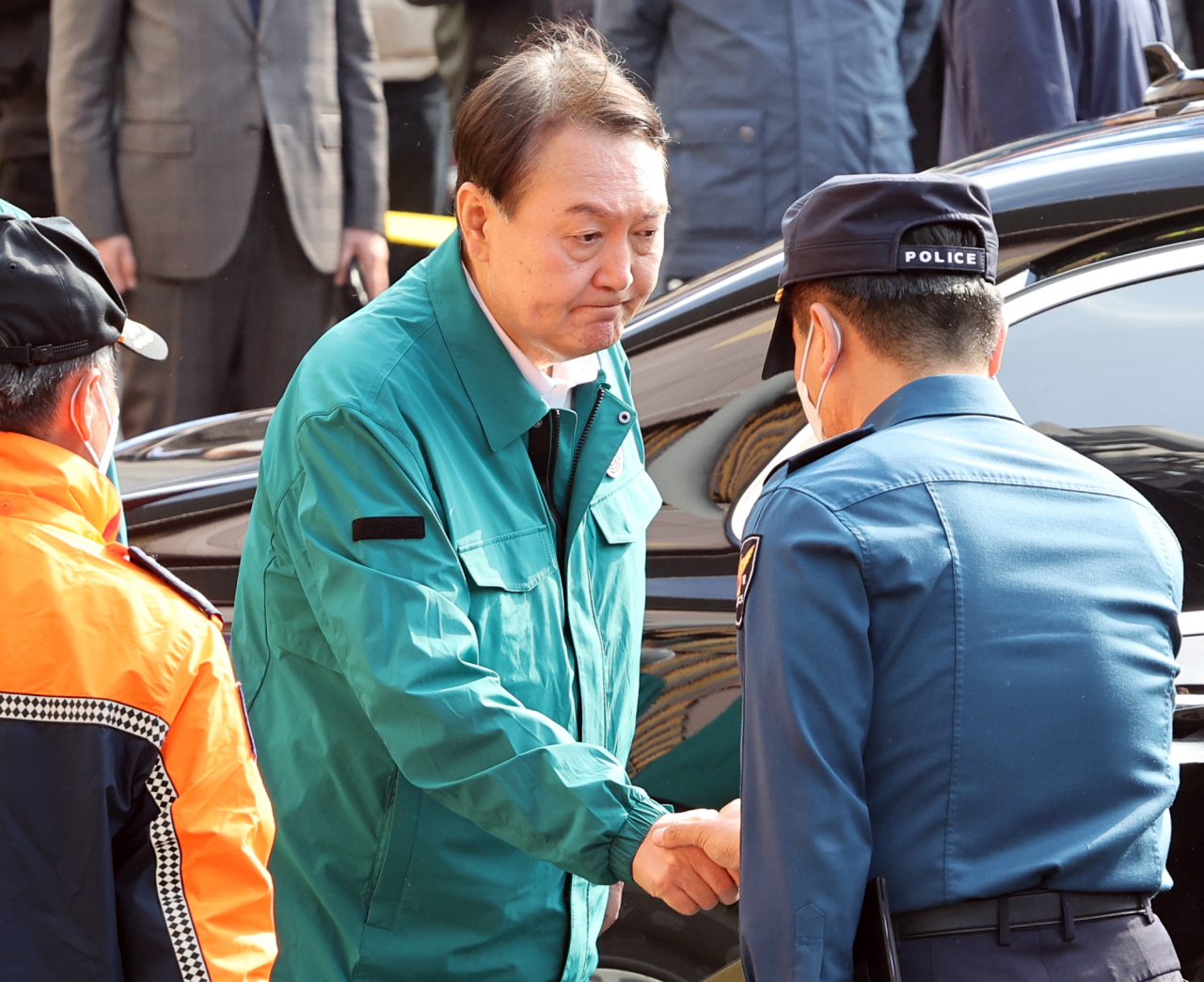 President Yoon Suk-yeol greets a police official after inspecting the site of the deadly crowd crush in Itaewon, Seoul, on Sunday. (Yonhap)