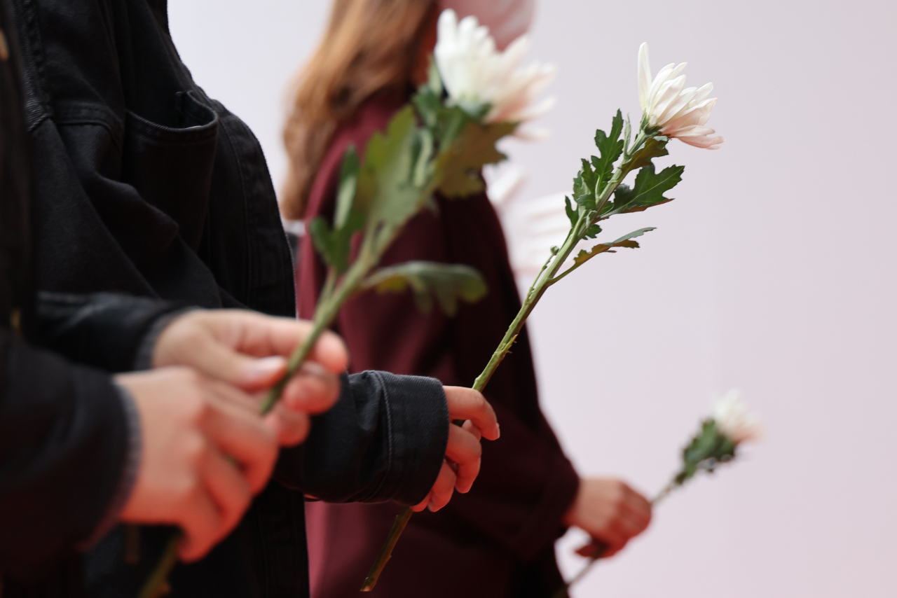 People place flowers at a memorial altar in front of City Hall in Seoul on Thursday. (Yonhap)