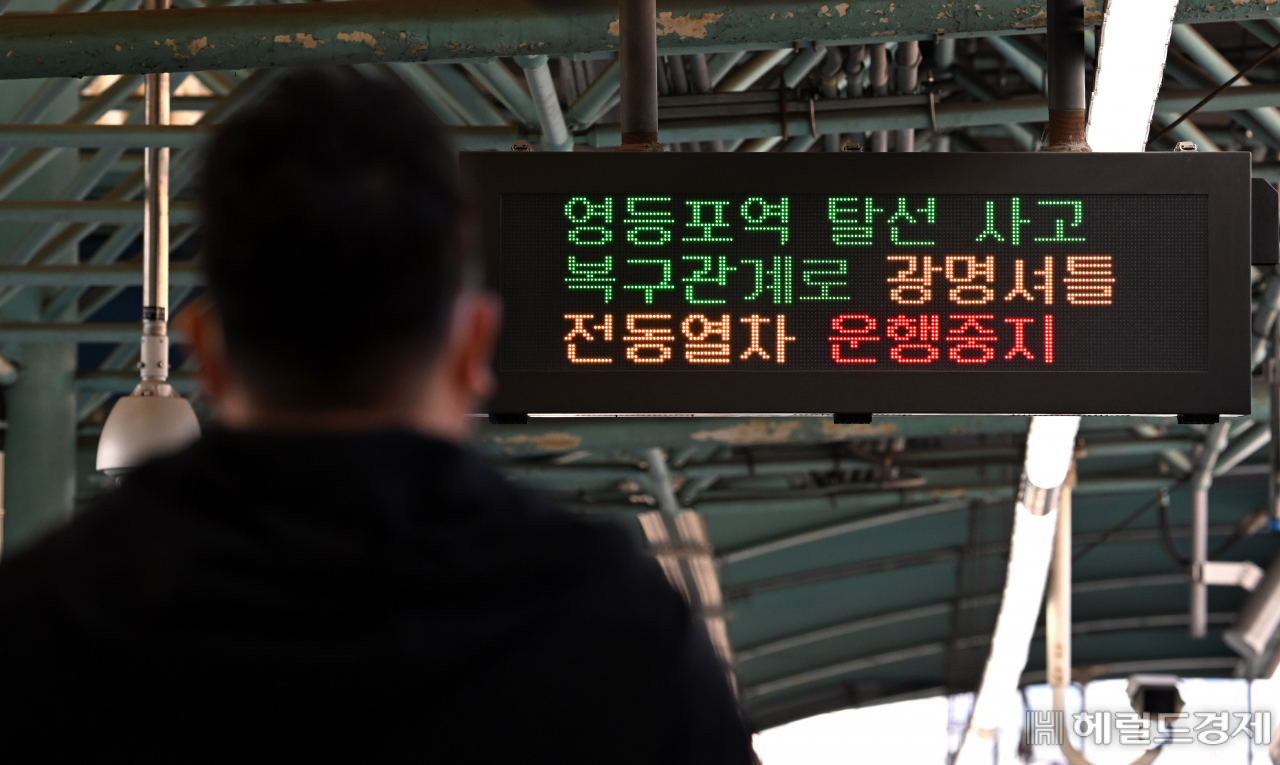 광명행 열차 운행중단 안내문 지켜보는 시민.