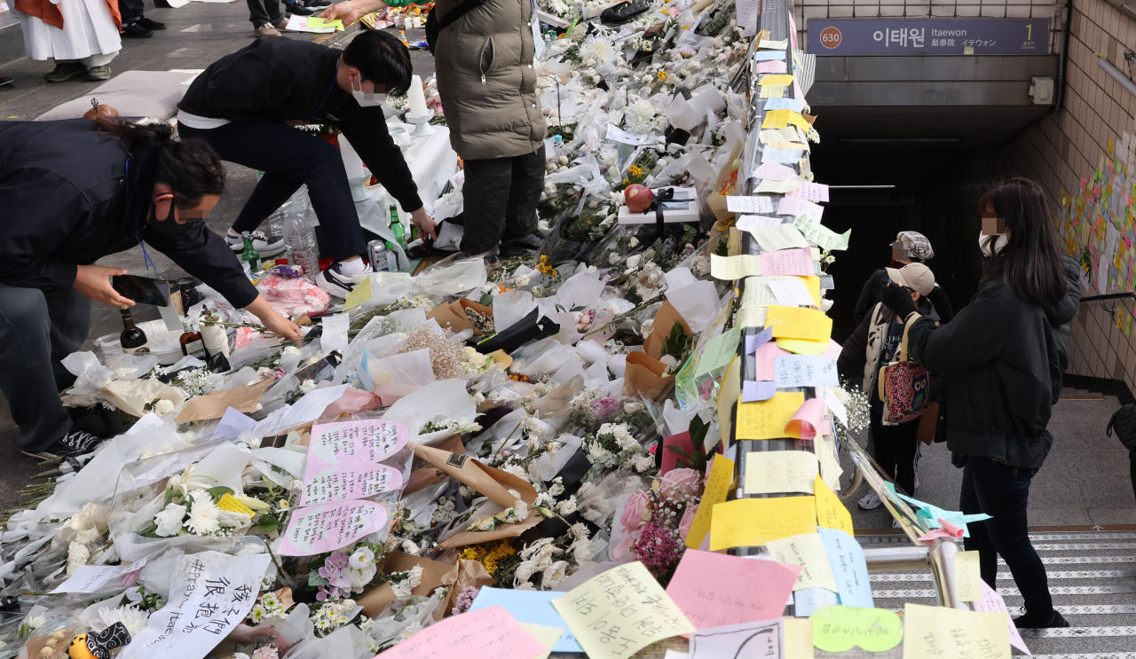 7일 이태원 참사 희생자 추모공간인 이태원역 1번 출구에서 자원봉사자들이 꽃을 정리하고 있다. 국가애도기간은 지난 5일 종료했다. [연합]