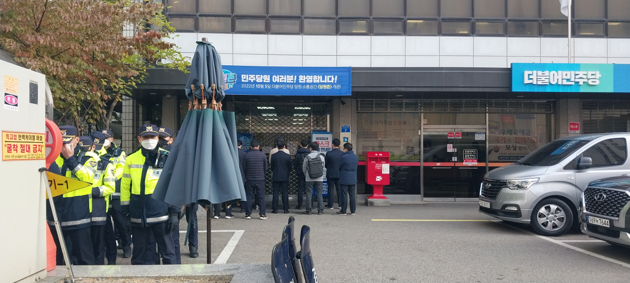 서울 여의도 민주당사 앞에서 검찰 수사관 수명이 당사 진입을 위해 정문 앞에 대기하고 있다. 검찰은 이날 오전 8시30분께 영장 집행을 위해 당사에 도착했다. [신현주 기자]