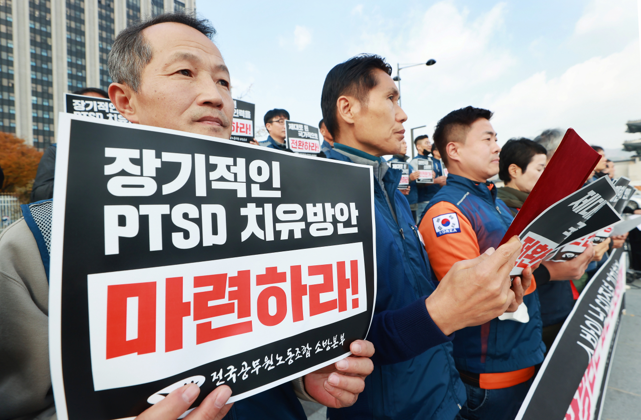 지난 8일 전국공무원노동조합 소방본부 조합원들이 서울 종로구 정부서울청사 앞에서 열린 소방의 날 60주년 ‘대한민국과 소방관은 과연 안전한가!’ 기자회견에서 손팻말을 들고 있다. [연합]