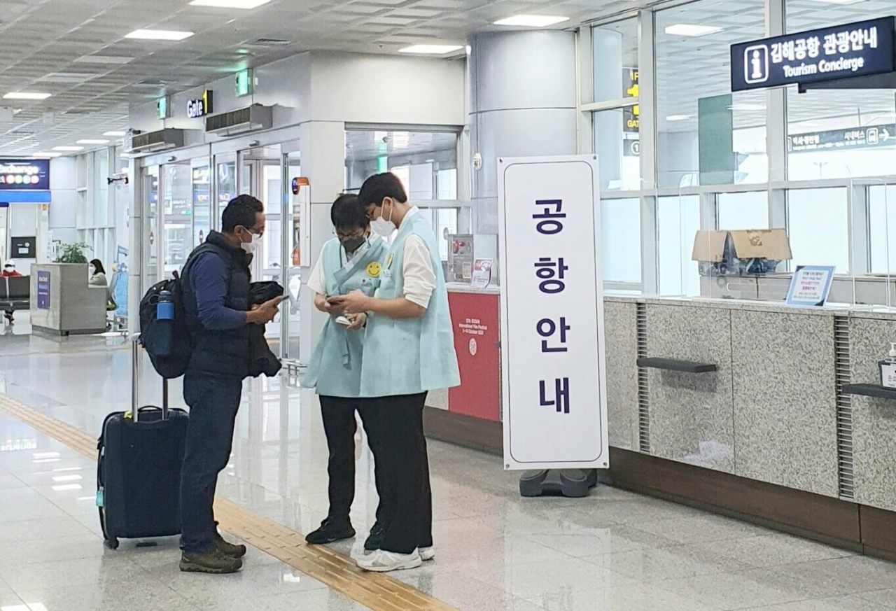 한복을 입은 김해공항 순찰형 안내요원이 외국인 관광객을 안내하고 있다.