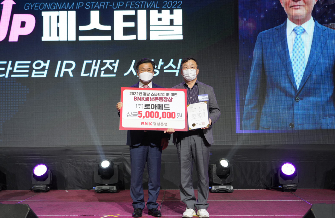 BNK경남은행 최홍영 은행장(사진 왼쪽)이 ‘2022 경남스타트업 IR대전’에서 우수상으로 선정된 ㈜로아메드 허성원 공동대표에게 BNK경남은행장상과 상금 500만원을 전달하고 있다. [경남은행 제공]