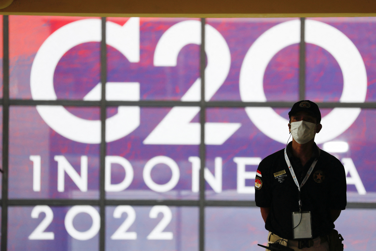 G20 정상회담이 오는 15일부터 이틀 간 인도네시아 발리에서 열린다. G20 정상회담을 알리는 대형 전시화면 앞에 경호요원이 서 있다.[연합=로이터]