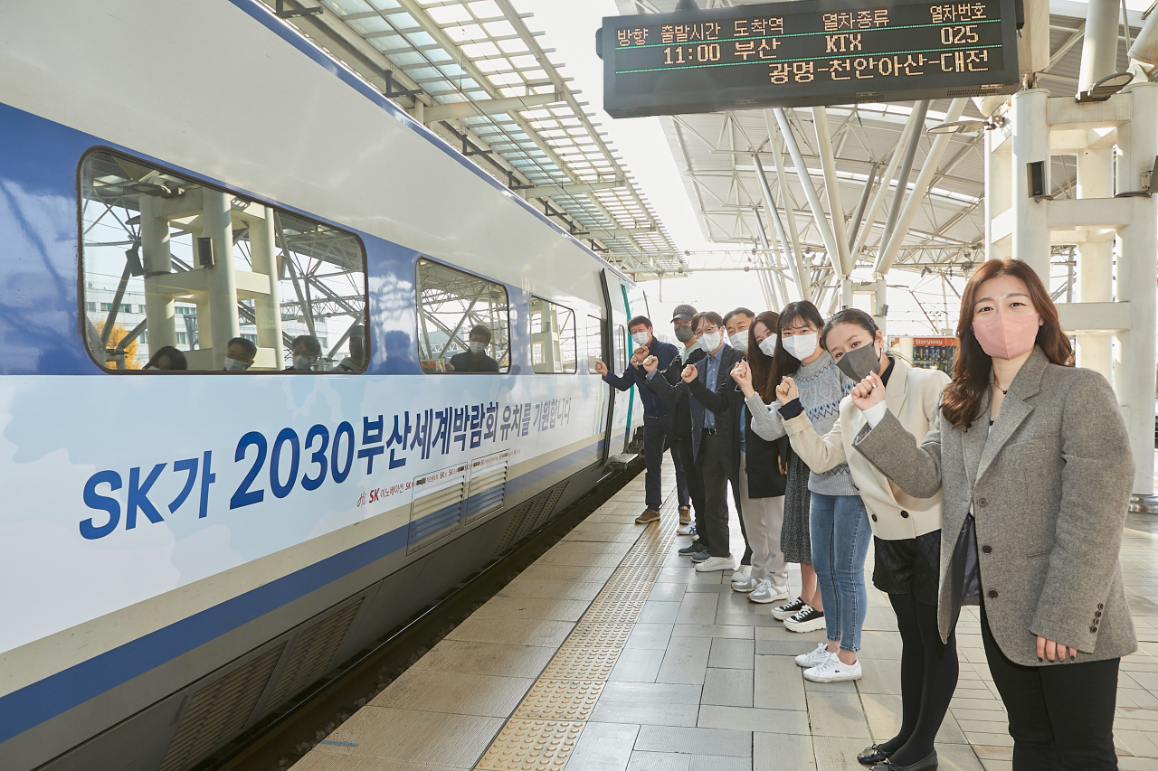 SK이노베이션 구성원들이 지난 11일 서울역 출발 대기 중인 KTX 랩핑열차 앞에서 2030 부산세계박람회 유치를 응원하고 있다. [SK이노베이션 제공]
