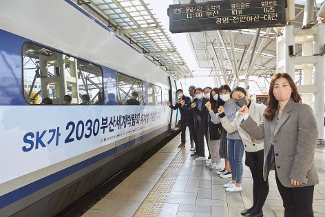 SK이노베이션 구성원들이 지난 11일 서울역 출발 대기 중인 KTX 랩핑열차 앞에서 2030 부산세계박람회 유치를 응원하고 있다. [SK이노베이션 제공]