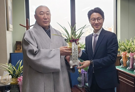 불교방송 신임 이사장에 선임된 덕문스님이 14일 이강래 행정관으로부터 축하의 난을 받고 있다. [화엄사 제공]