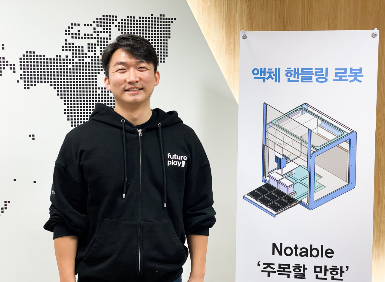 신상 캡스 토토사이트 대표가 인천 송도에 있는 사옥 입구에서 액체 핸들링 로봇 ‘노터블’을 소개하고 있다. [캡스 토토사이트 제공]
