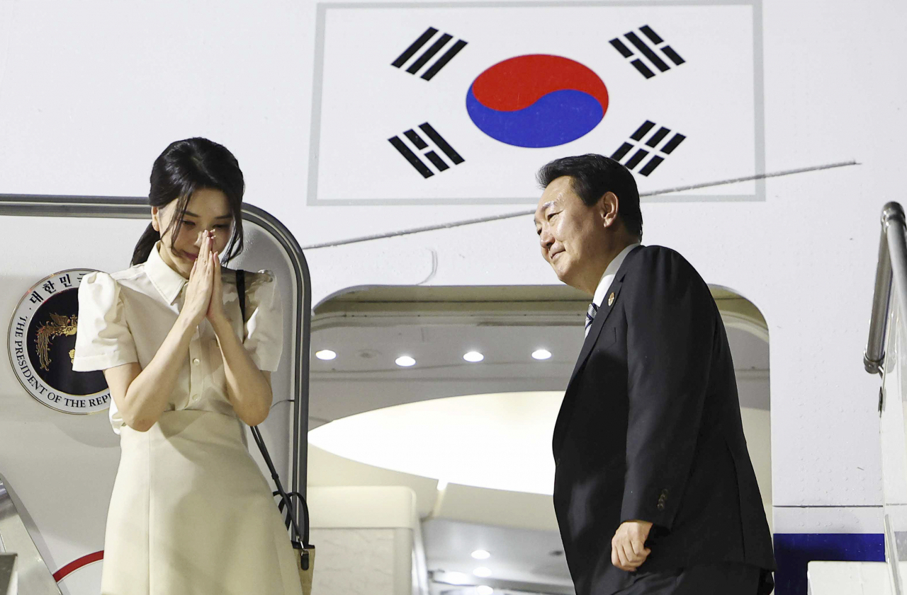 윤석열 대통령과 김건희 여사가 한·아세안 정상회의 등의 일정을 마친 뒤 주요 20개국(G20) 정상회의가 열리는 인도네시아 발리로 출국하기 위해 13일(현지시간) 캄보디아 프놈펜국제공항에 도착, 공군 1호기에서 인사하고 있다. [연합]