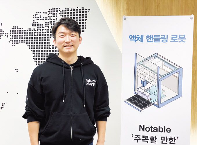 신상 에이블랩스 대표가 인천 송도에 있는 사옥 입구에서 액체 핸들링 로봇 ‘노터블’을 소개하고 있다. [에이블랩스 제공]