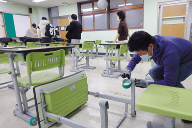 수능을 이틀 앞둔 15일 오후 서울 영등포구 선유고등학교에서 선생님과 학생들이 잡음이 나는 책걸상 등을 손보고 있다. [연합]