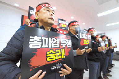 민주노총 전국공공운수노동조합 화물연대본부 조합원들이 14일 오전 서울 강서구 공공운수노조에서 열린 총파업 선포 기자회견에서 국토교통부와 화물연대 간 합의를 파기한 국토교통부를 규탄하고 안전운임 일몰제 폐지를 촉구하며 손팻말을 들고 있다. 화물연대는 이날 기자회견에서 24일 0시를 기해 무기한 전면 총파업에 돌입한다고 밝혔다. [연합]