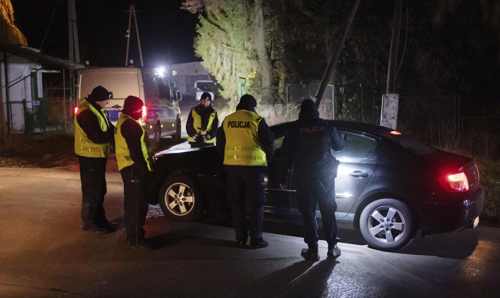 Police officers gather outside a grain depot in Przewodow, eastern Poland, on Tuesday, where the Polish Foreign Ministry said that a Russian-made missile fell and killed two people. The ministry said Foreign Minister Zbigniew Rau summoned the Russian ambassador and "demanded immediate detailed explanations." (AP Photo)