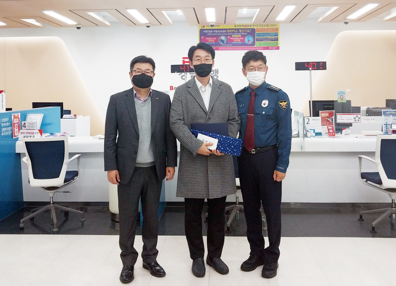 BNK경남은행 삼천포지점 직원(사진 가운데)이 보이스피싱을 예방한 공로로 사천경찰서 우문영 서장으로부터 감사장을 받고 있다. [BNK경남은행 제공]
