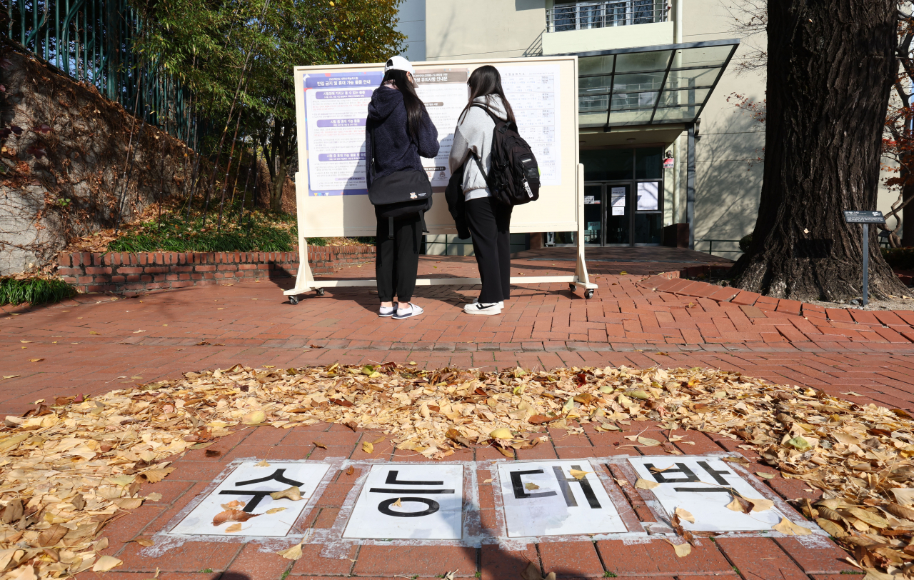 2023학년도 대학수학능력시험(수능) 예비소집일인 16일 서울 중구 이화여자고등학교에서 수험생들이 시험실 배치도와 유의사항 안내문 등을 확인하고 있다. [연합]