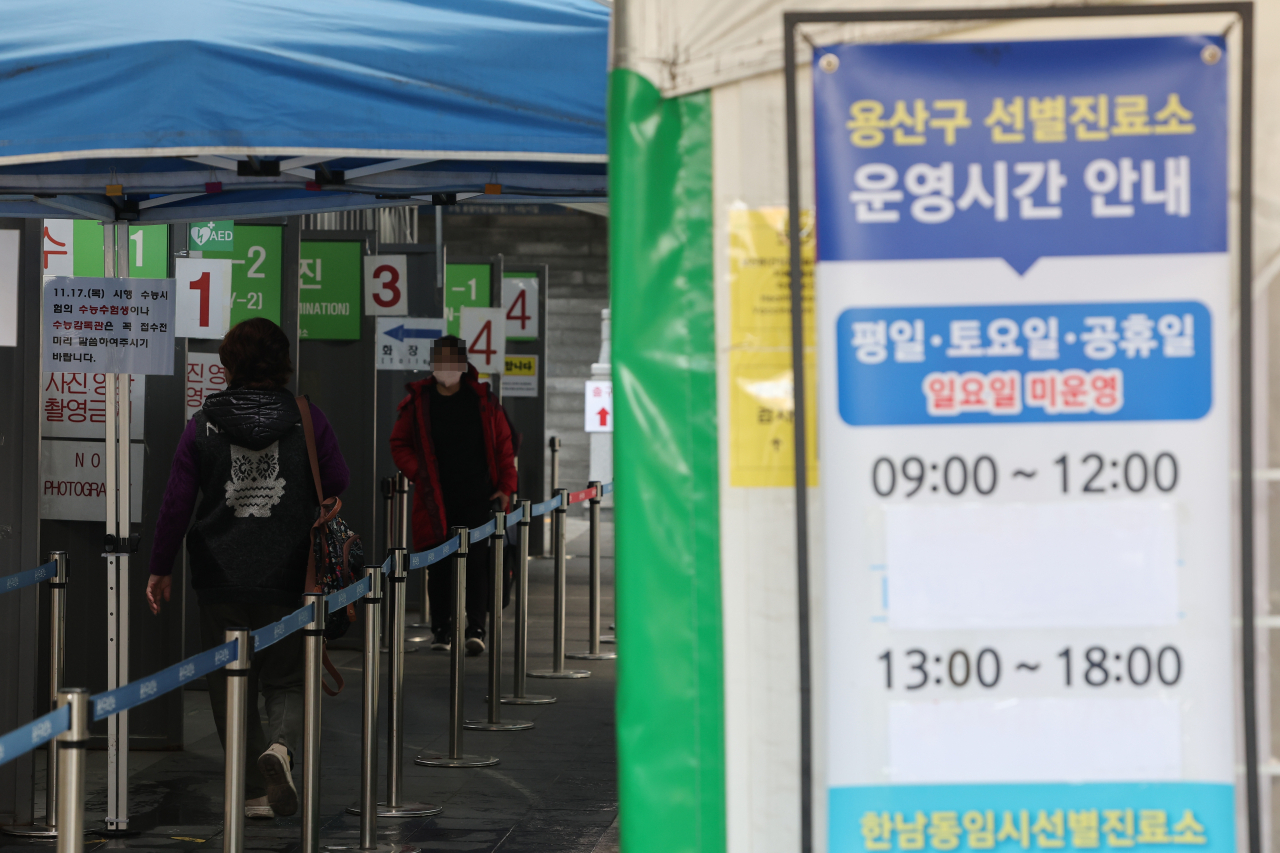 People line up to undergo COVID-19 tests at a makeshift testing station in Seoul on Wednesday. (Yonhap)